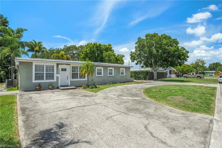 Ranch-style house with a front lawn and cooling unit