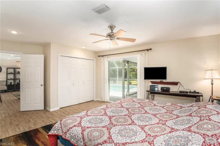 Bedroom featuring light hardwood / wood-style flooring, a closet, access to outside, a textured ceiling, and ceiling fan