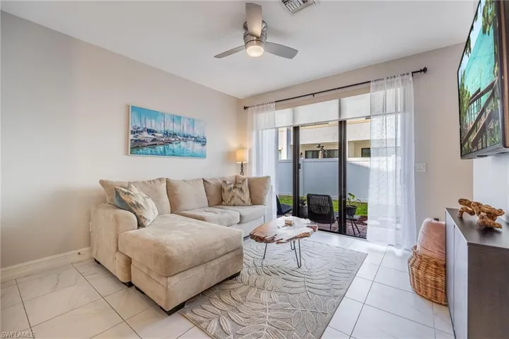 Living area with a ceiling fan, visible vents, and baseboards