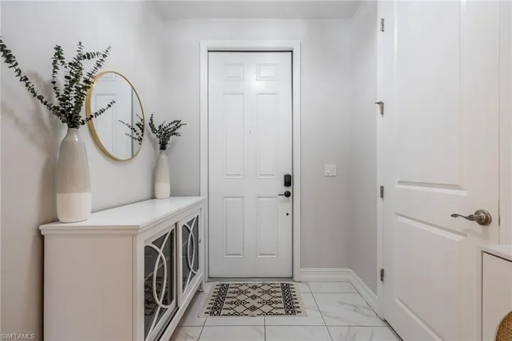 Foyer entrance with marble finish floor and baseboards