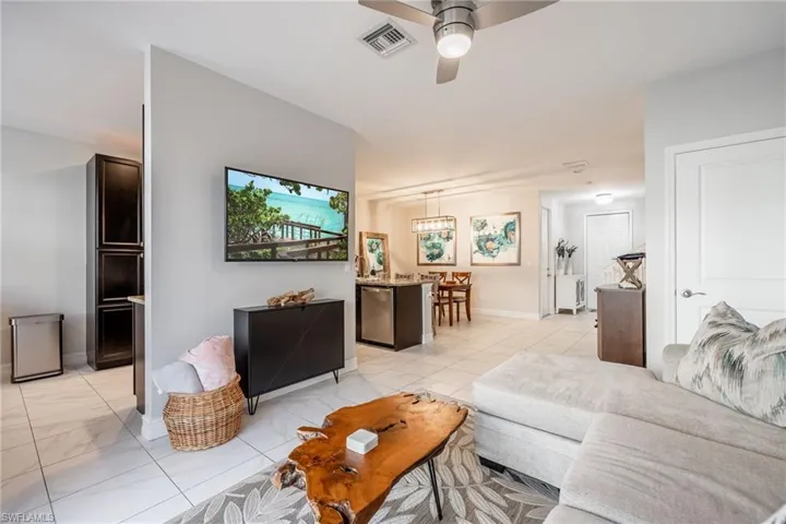 Living area with marble finish floor, ceiling fan, visible vents, and baseboards