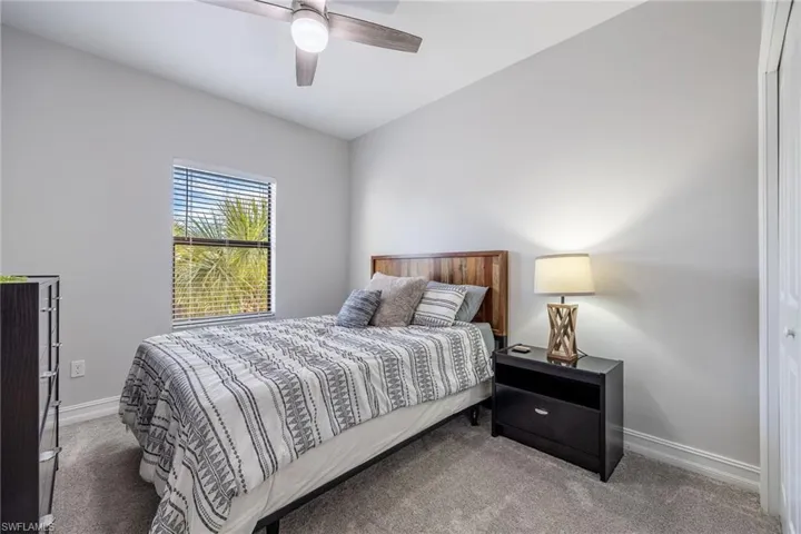 Carpeted bedroom with baseboards and a ceiling fan