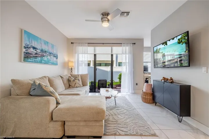 Living room with ceiling fan, visible vents, and baseboards