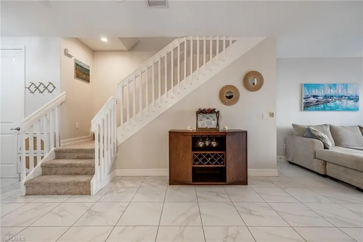 Staircase featuring recessed lighting, marble finish floor, visible vents, and baseboards