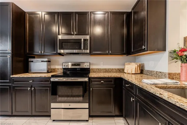 Kitchen with appliances with stainless steel finishes and light stone countertops