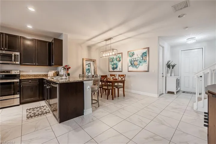 Kitchen featuring dark brown cabinets, appliances with stainless steel finishes, a sink, and visible vents