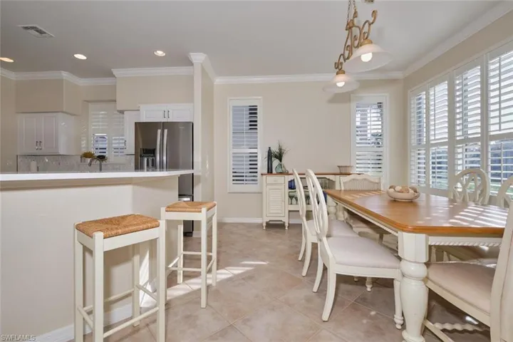 Dining space with ornamental molding and light tile patterned floors