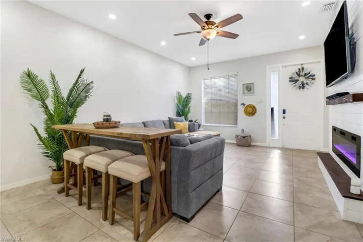 Living room featuring light tile patterned floors and ceiling fan