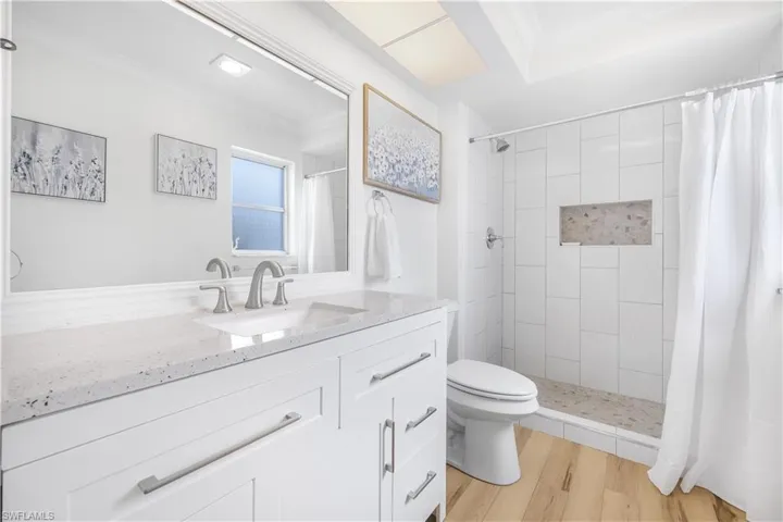 Full bathroom featuring vanity, a shower stall, and light wood finished floors