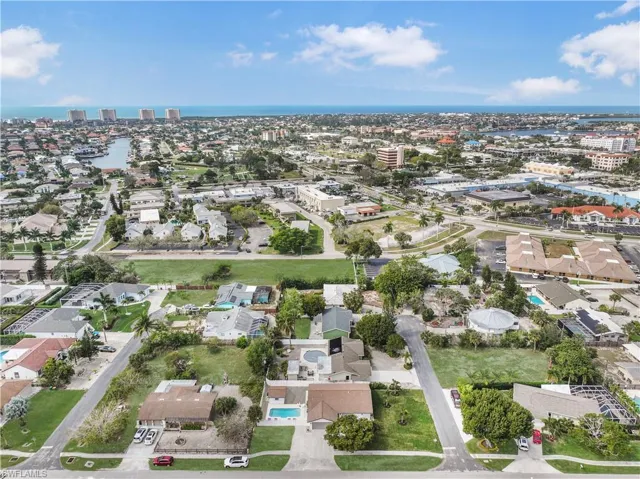 Aerial view of property and surrounding area featuring nearby suburban area