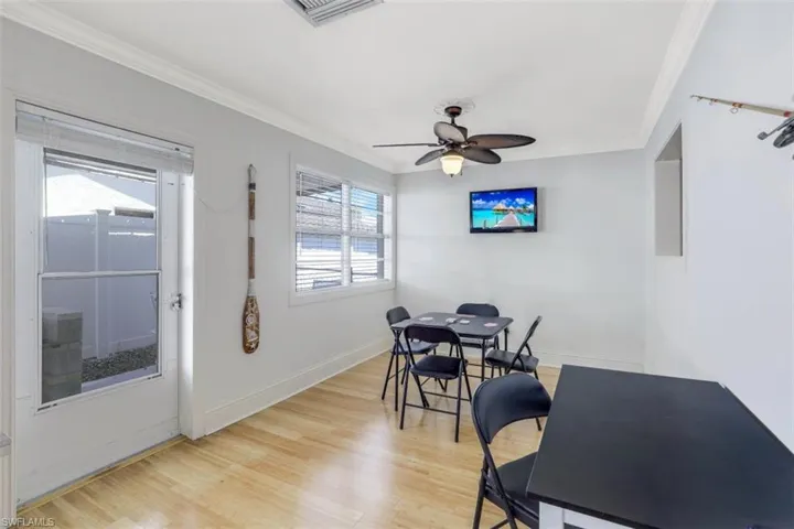 Dining room with ornamental molding, light wood-style floors, and ceiling fan