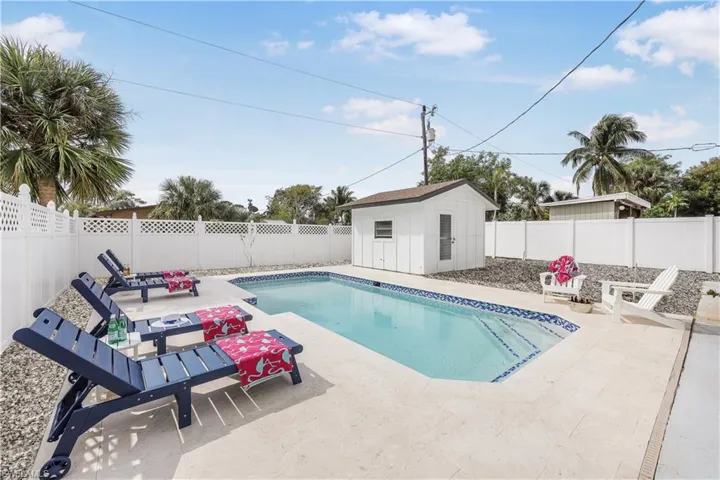 View of swimming pool with a fenced backyard, an outbuilding, and a patio