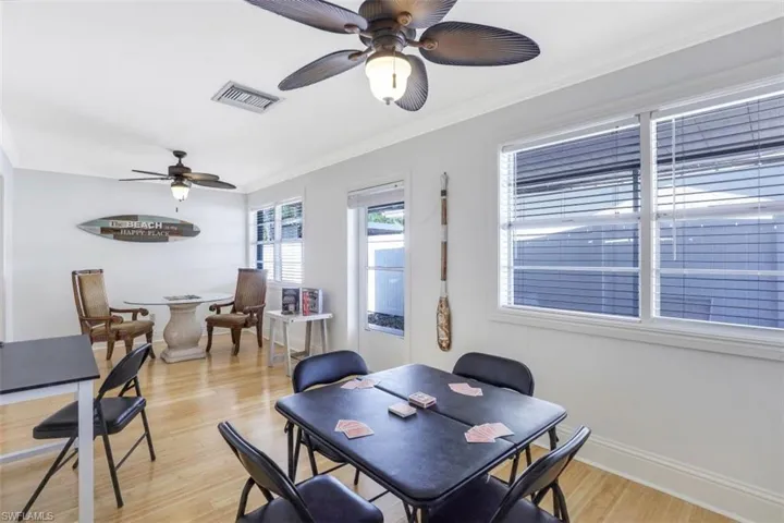 Dining space with light wood-type flooring, ornamental molding, and a ceiling fan