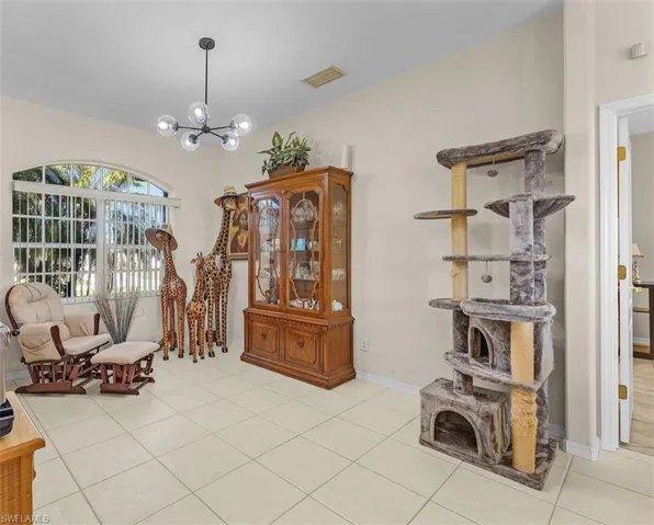 Sitting room with light tile patterned floors, visible vents, a chandelier, and baseboards