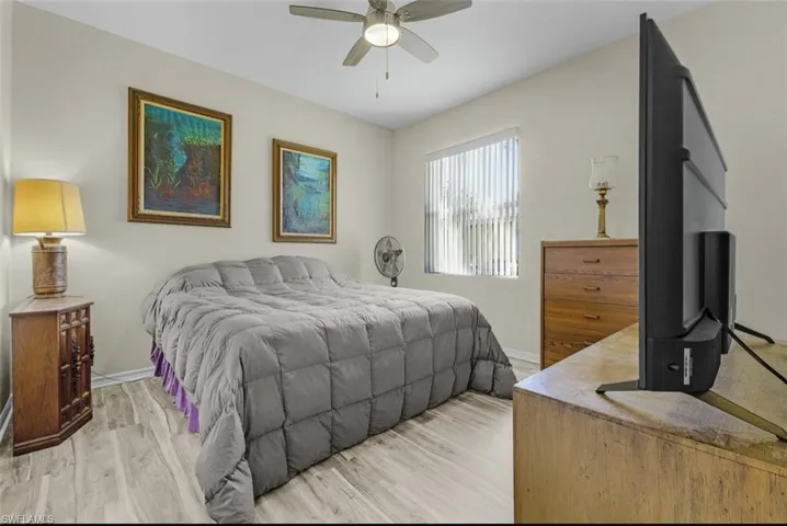 Bedroom with baseboards, light wood-type flooring, and ceiling fan