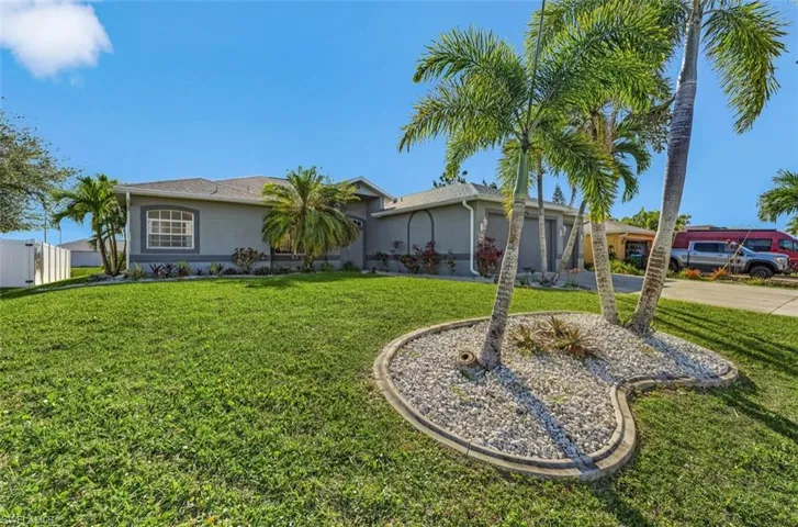 Single story home with a front lawn, stucco siding, concrete driveway, and an attached garage
