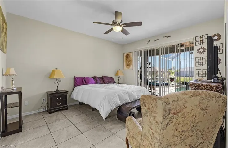 Bedroom with light tile patterned floors, a ceiling fan, access to exterior, and baseboards