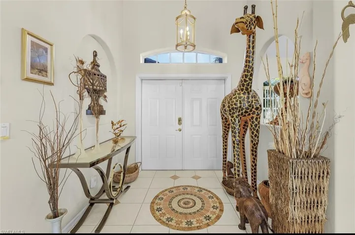 Entryway with light tile patterned floors, a chandelier, and a high ceiling