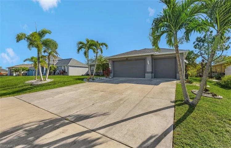 Ranch-style home featuring a garage, a front lawn, driveway, and stucco siding