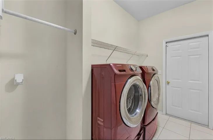 Clothes washing area with light tile patterned floors, laundry area, and independent washer and dryer