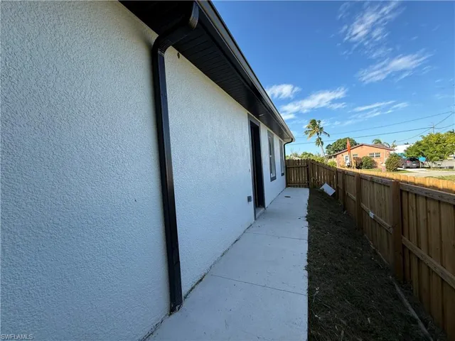 View of side of property featuring stucco siding and a fenced backyard
