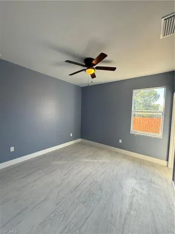 Unfurnished room with baseboards and ceiling fan