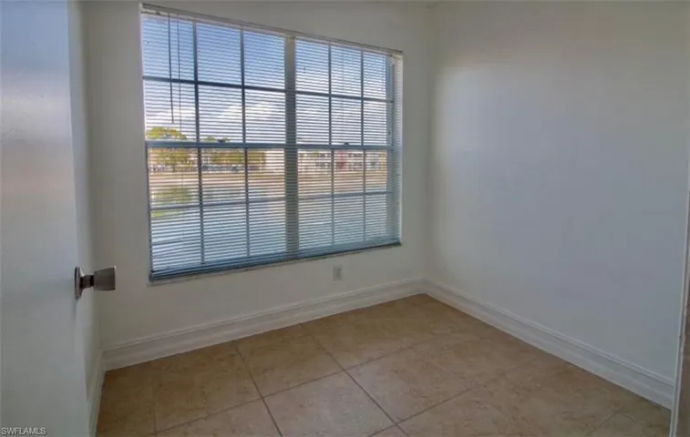 Spare room with baseboards and light tile patterned floors