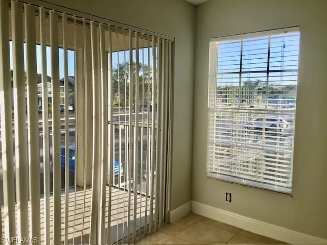 Doorway to outside featuring baseboards, tile patterned flooring, and plenty of natural light