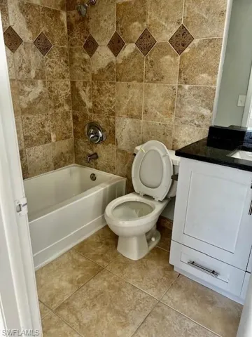 Full bath featuring toilet, tub / shower combination, vanity, and tile patterned flooring