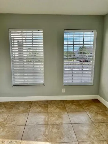 Empty room featuring tile patterned flooring and baseboards