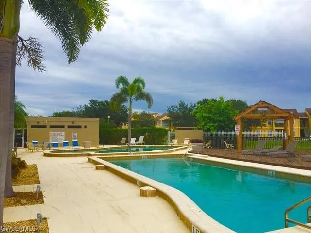 Community pool featuring a gazebo, a patio area, and fence