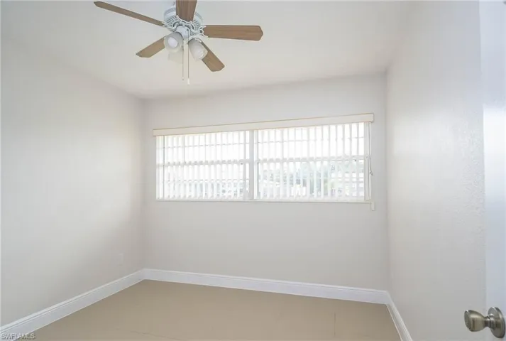 Unfurnished room with ceiling fan and plenty of natural light
