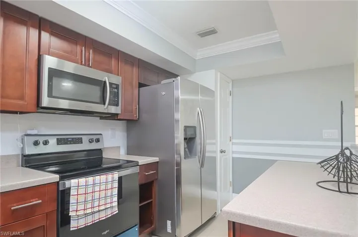 Kitchen featuring appliances with stainless steel finishes and crown molding