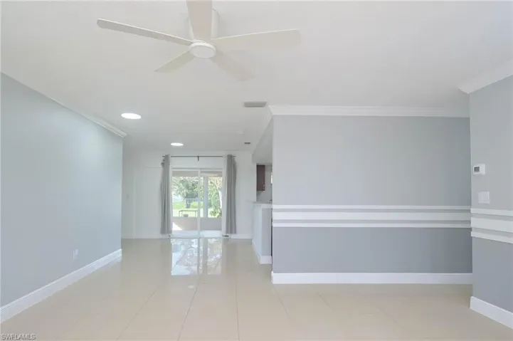 Tiled spare room featuring crown molding and ceiling fan