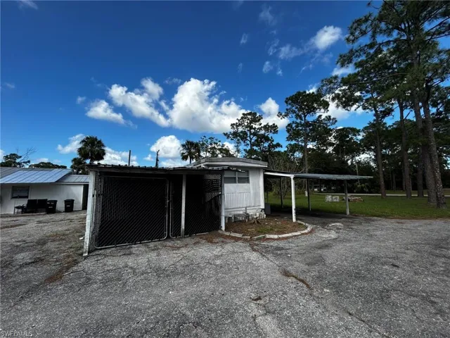 View of outbuilding featuring a carport and a lawn