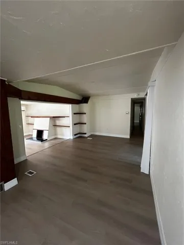Unfurnished living room with lofted ceiling and hardwood / wood-style floors
