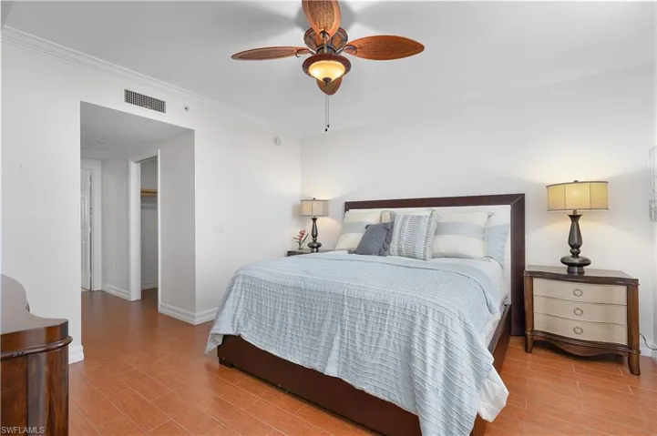 Bedroom featuring crown molding, baseboards, light wood finished floors, and a ceiling fan