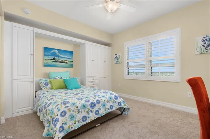 Carpeted bedroom featuring baseboards, a closet, and a ceiling fan