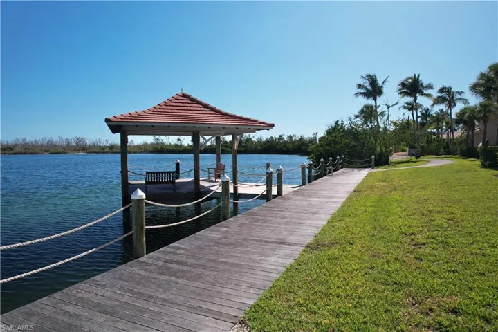 Dock area with a yard, a water view, and a gazebo