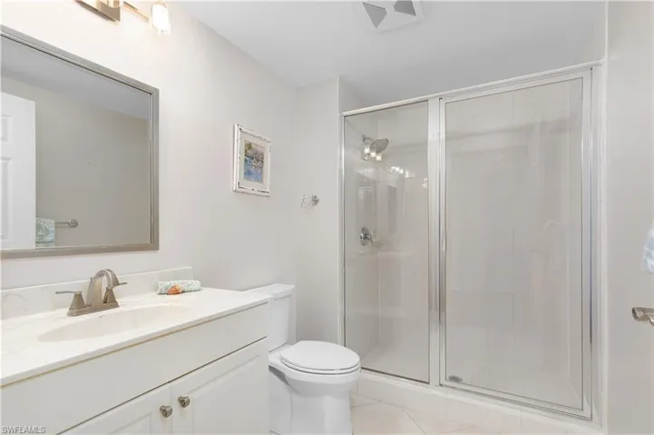 Full bath featuring a stall shower, toilet, tile patterned flooring, and vanity