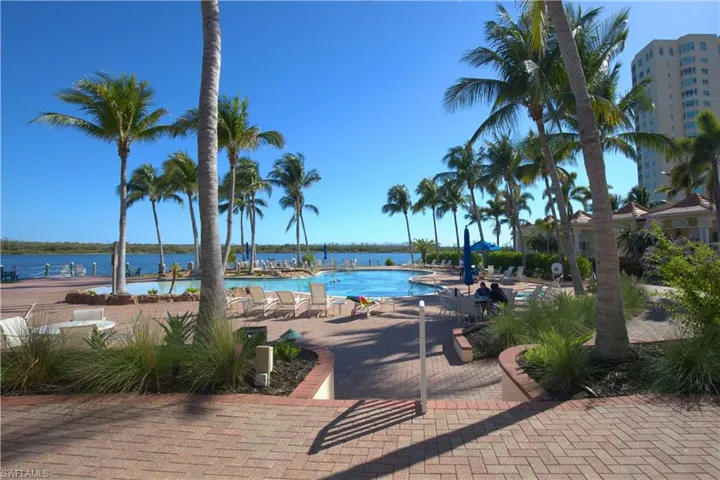 Community pool featuring a water view and a patio area