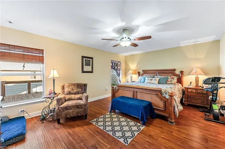 Bedroom featuring multiple windows, hardwood / wood-style floors, and ceiling fan