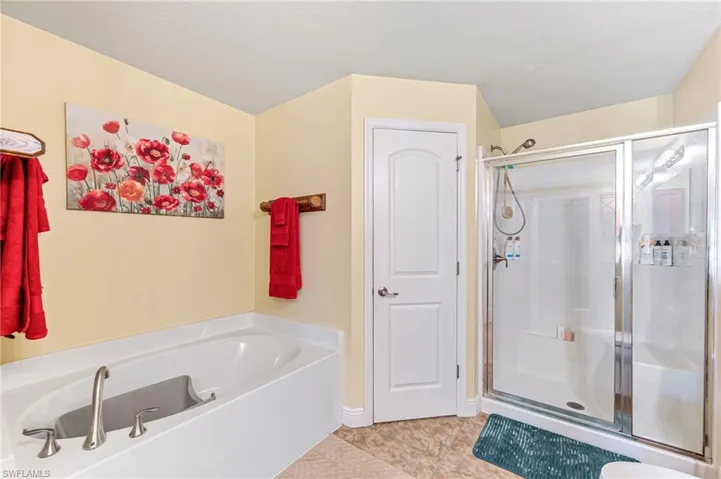 Bathroom featuring tile patterned flooring and independent shower and bath