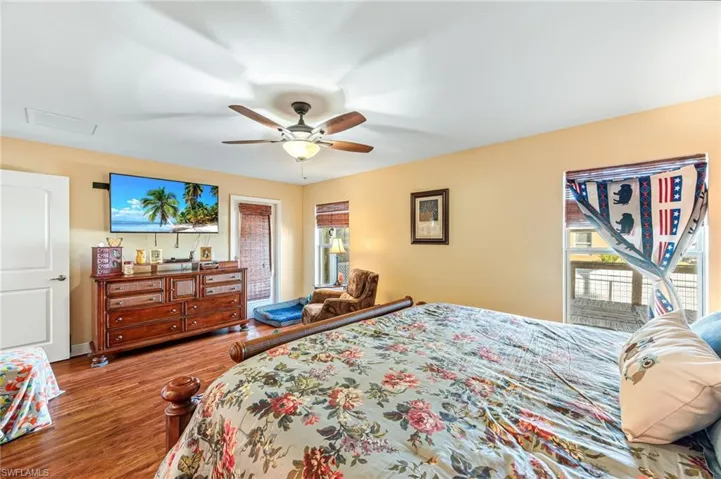 Bedroom featuring multiple windows, ceiling fan, and hardwood / wood-style flooring