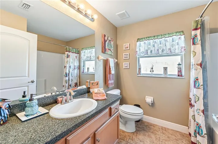 Bathroom featuring tile patterned floors, vanity, and toilet