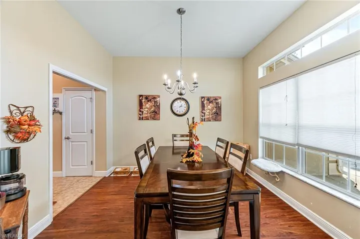 Dining space with a notable chandelier and hardwood / wood-style flooring