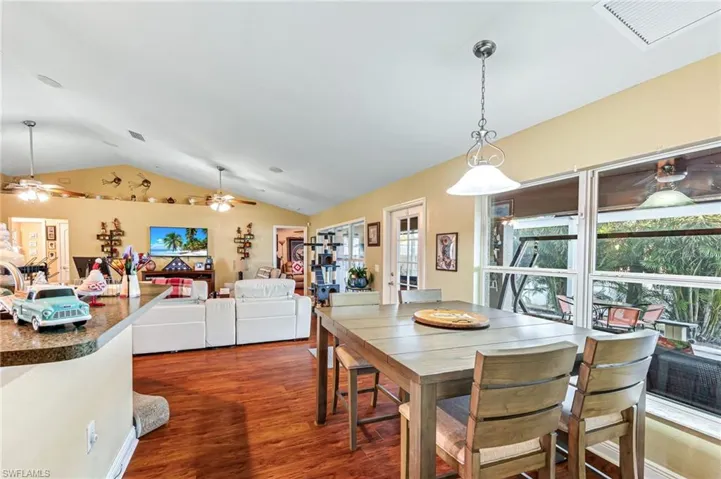 Dining area with ceiling fan, dark hardwood / wood-style flooring, and lofted ceiling