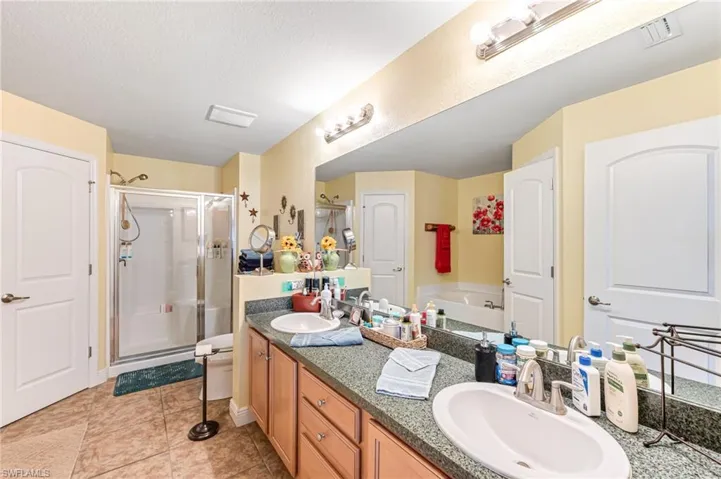 Bathroom with vanity, a textured ceiling, tile patterned floors, and independent shower and bath