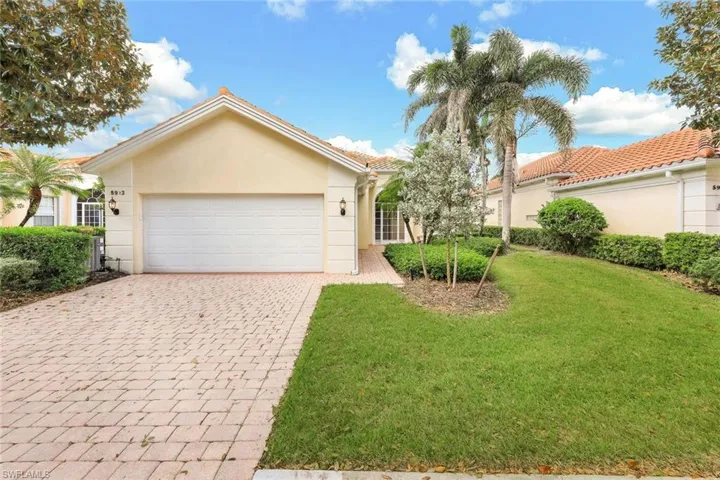 View of front of house with a garage and a front lawn