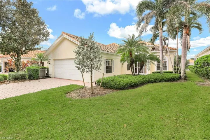 Mediterranean / spanish home featuring central AC, a garage, and a front lawn